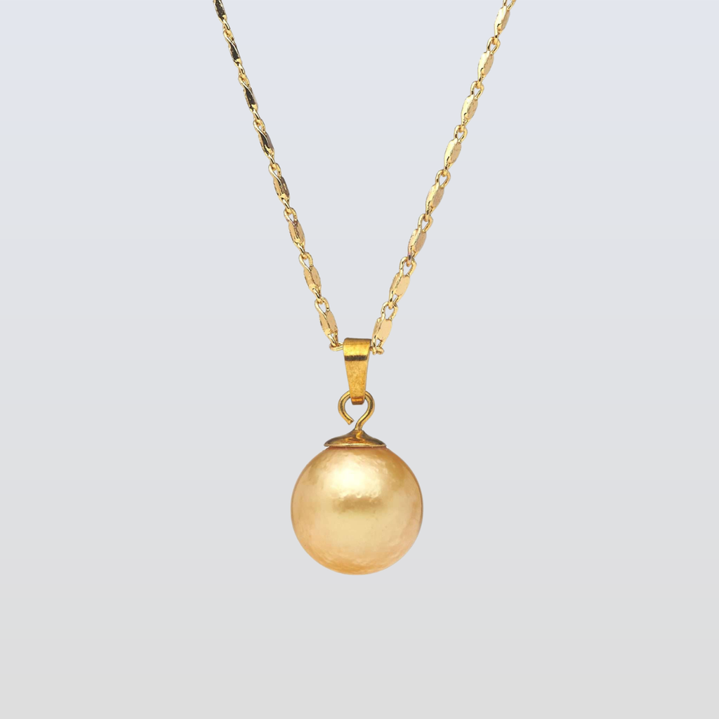 Gold necklace with a round pendant on a light gray background