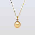 Gold necklace with a round pendant on a light gray background