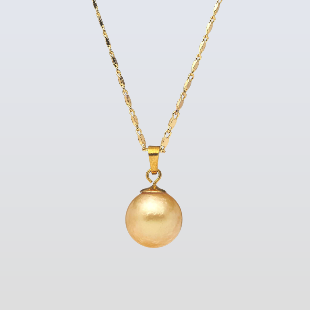Gold necklace with a round pendant on a light gray background