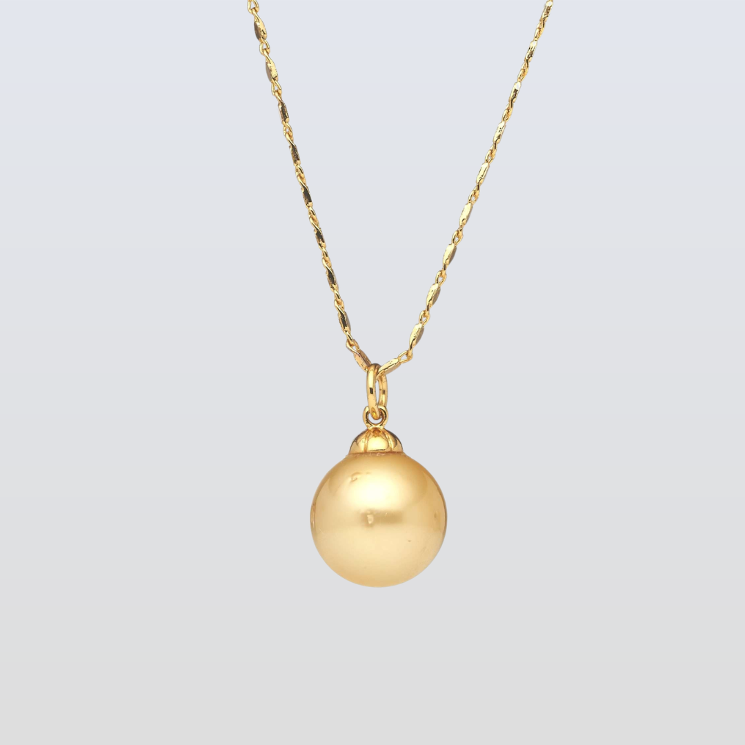 Gold necklace with a round pendant on a light gray background