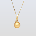 Gold necklace with a round pendant on a light gray background