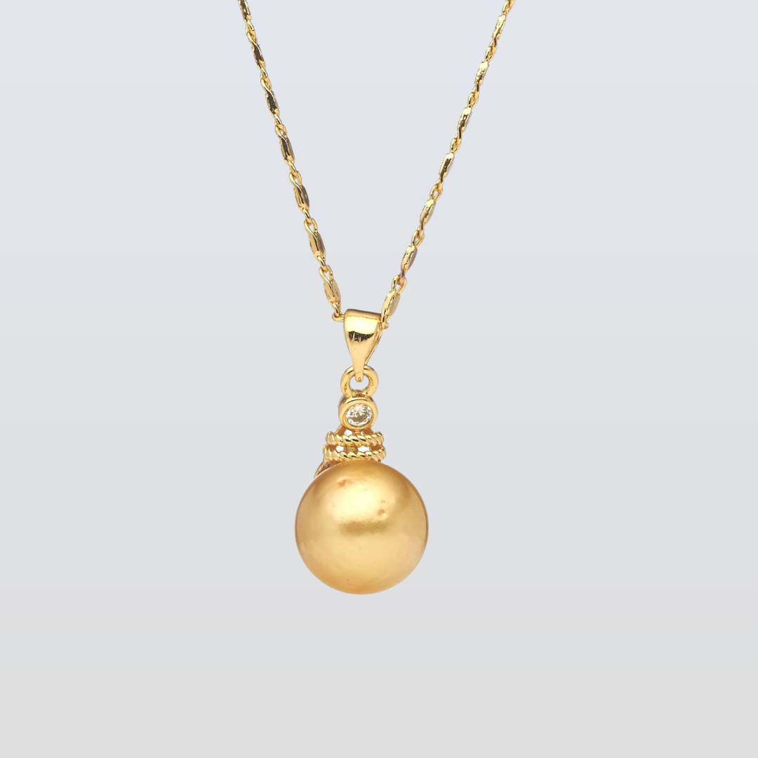 Gold necklace with a round pendant on a light gray background