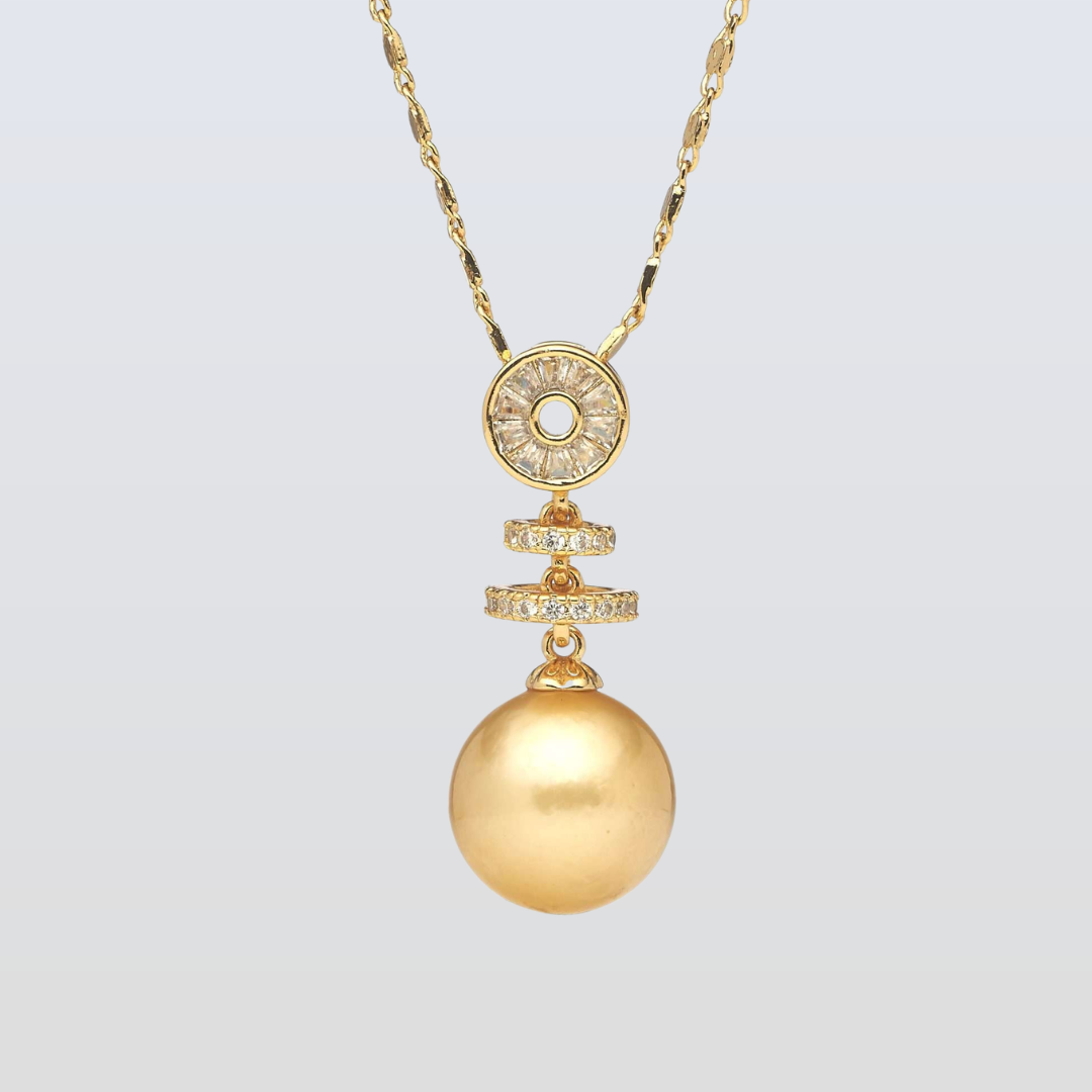 Gold necklace with a large round pendant and smaller circular pendant on a light gray background