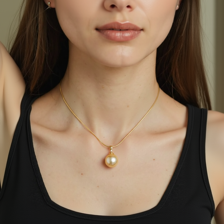 Gold necklace with a pearl pendant worn by a person