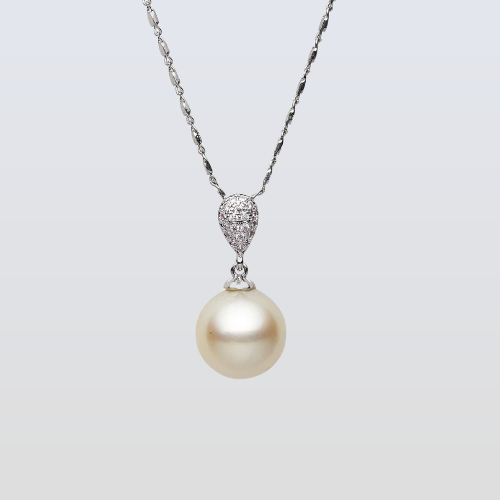 Pearl necklace with a silver chain on a light gray background