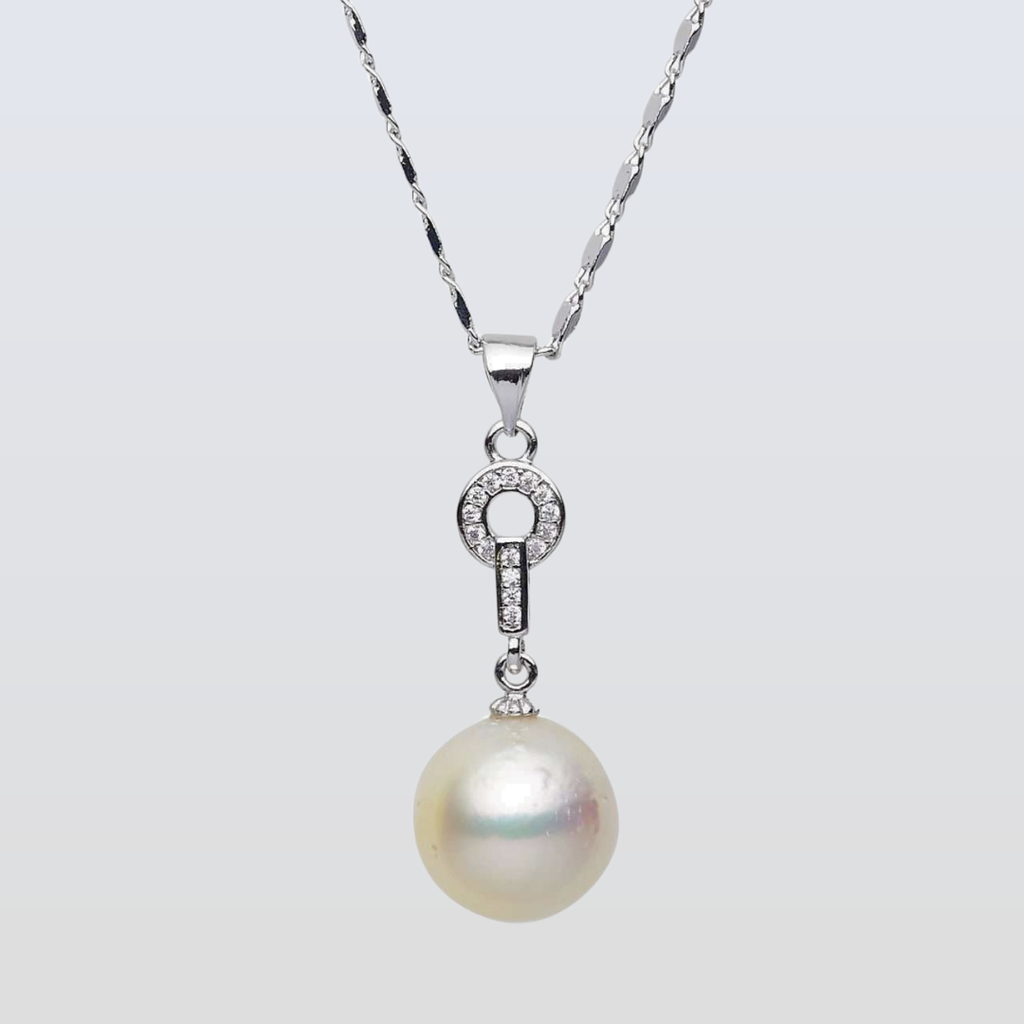 Pearl necklace with silver chain on a light gray background