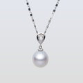 Pearl necklace with a silver chain on a light gray background