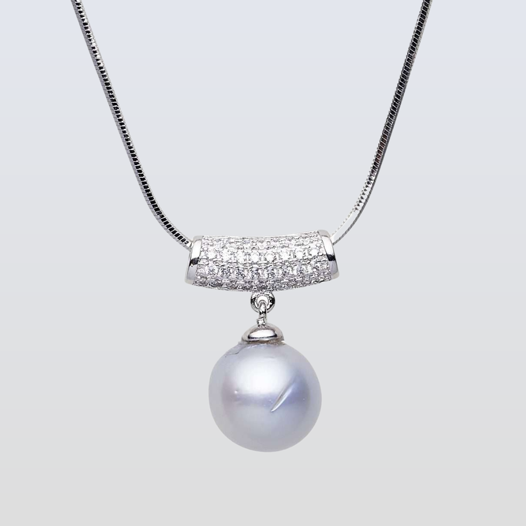 Pearl necklace with a silver chain and pendant on a light gray background