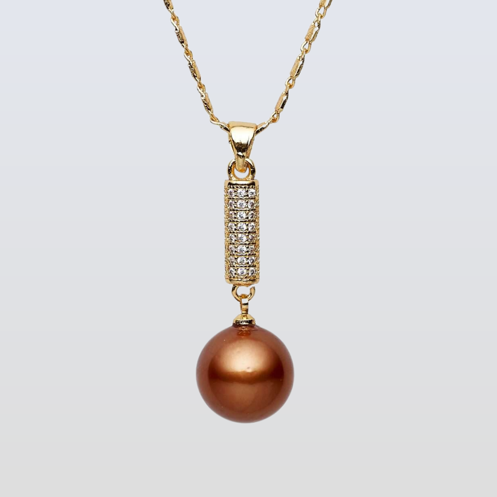 Gold necklace with a brown pearl pendant on a light gray background