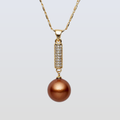 Gold necklace with a brown pearl pendant on a light gray background