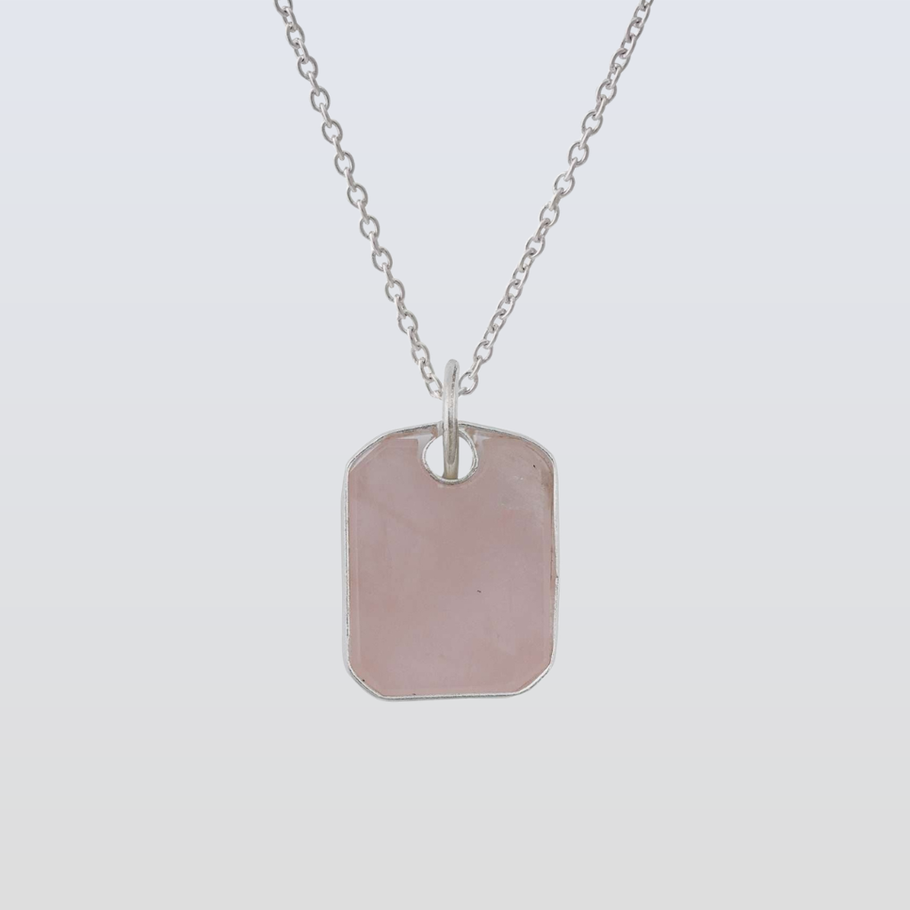 Silver dog tag necklace on a light gray background