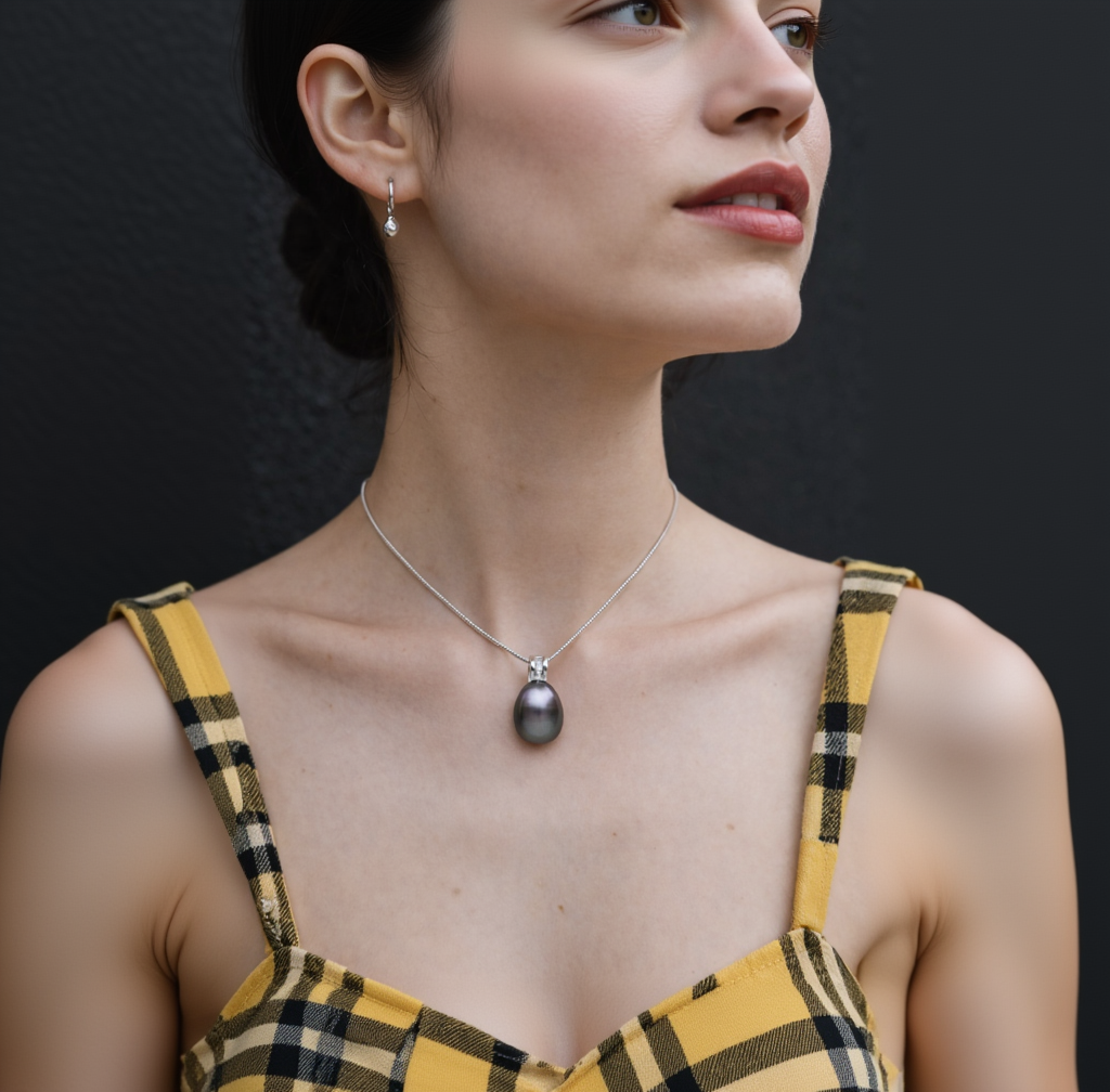 Close-up of a woman wearing a necklace with a pendant, earrings, and a yellow plaid top.