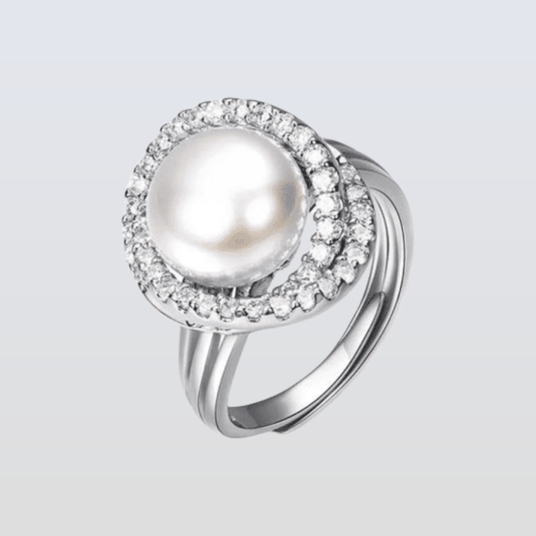 Silver ring with a pearl and small diamonds on a light gray background