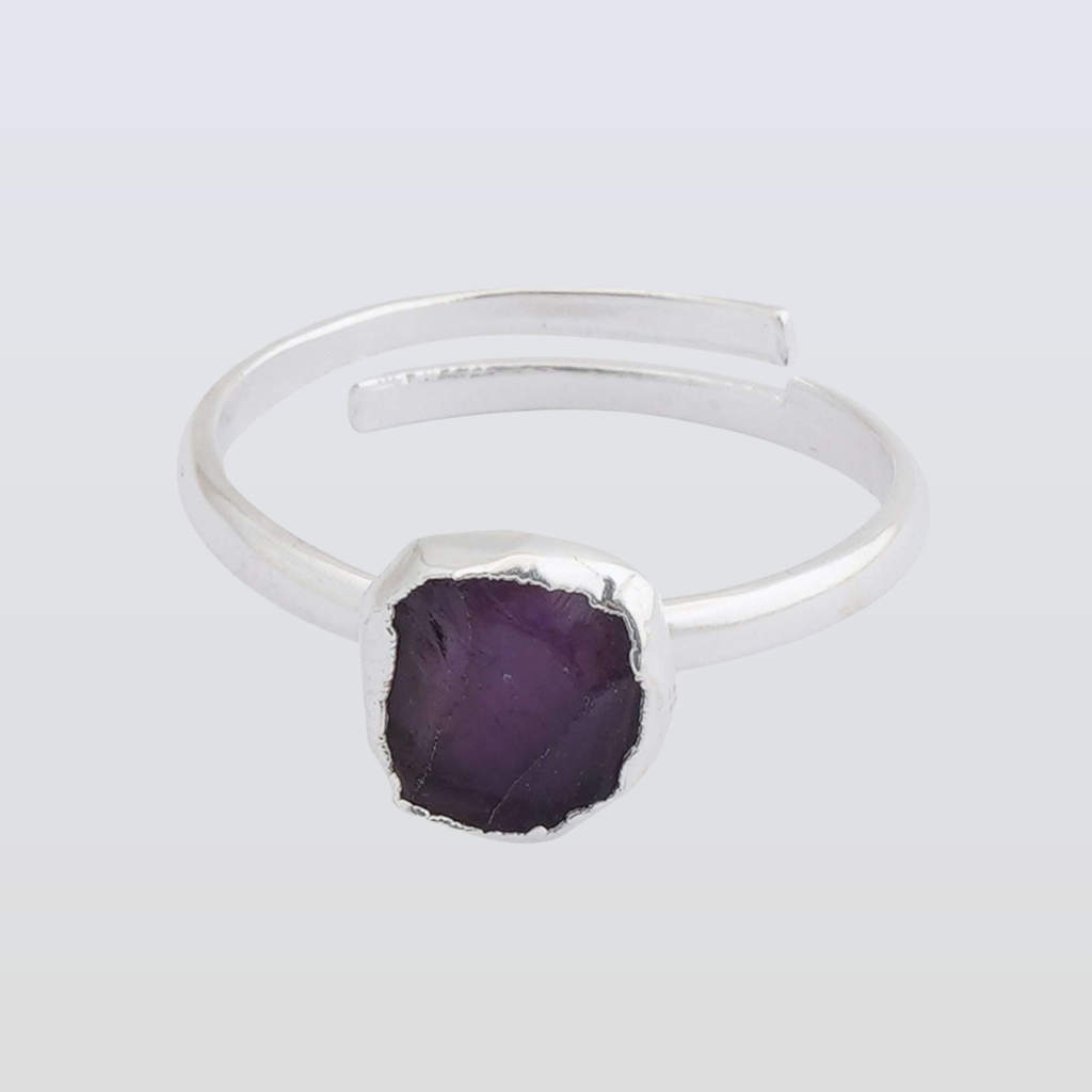 Silver ring with a purple stone on a light gray background