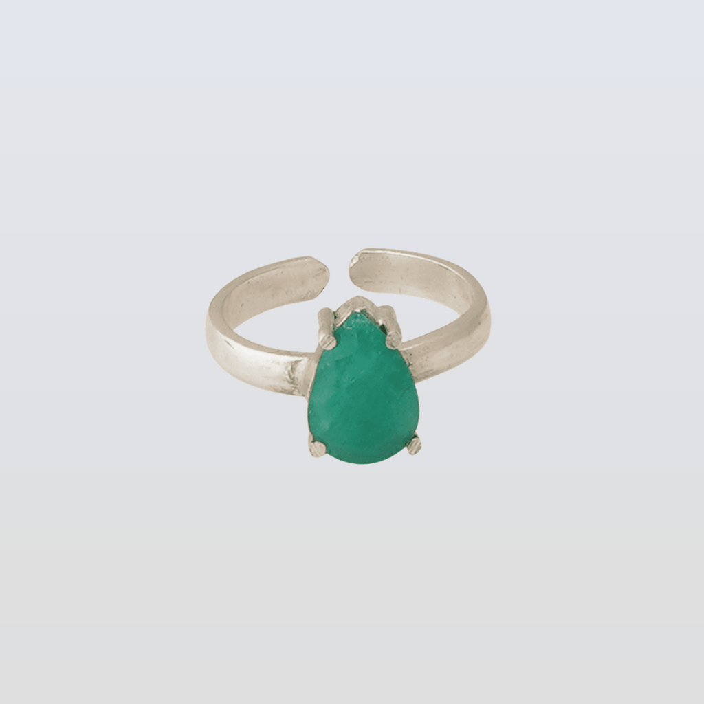 Silver ring with a green gemstone on a light gray background