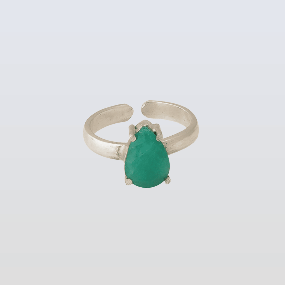 Silver ring with a green gemstone on a light gray background