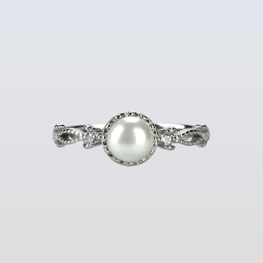 Pearl ring with silver band on a light gray background