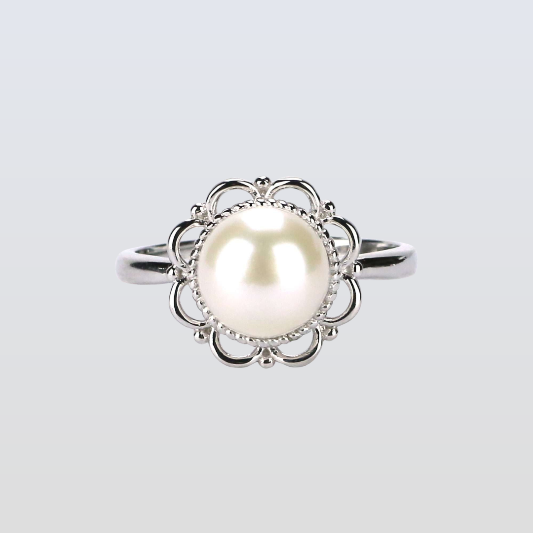 Pearl ring with silver floral design on a light gray background