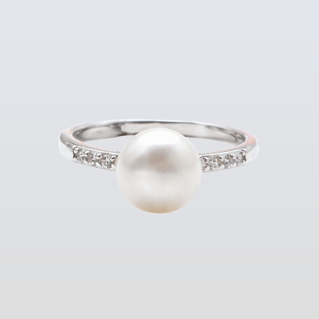 Pearl ring with a silver band on a light gray background