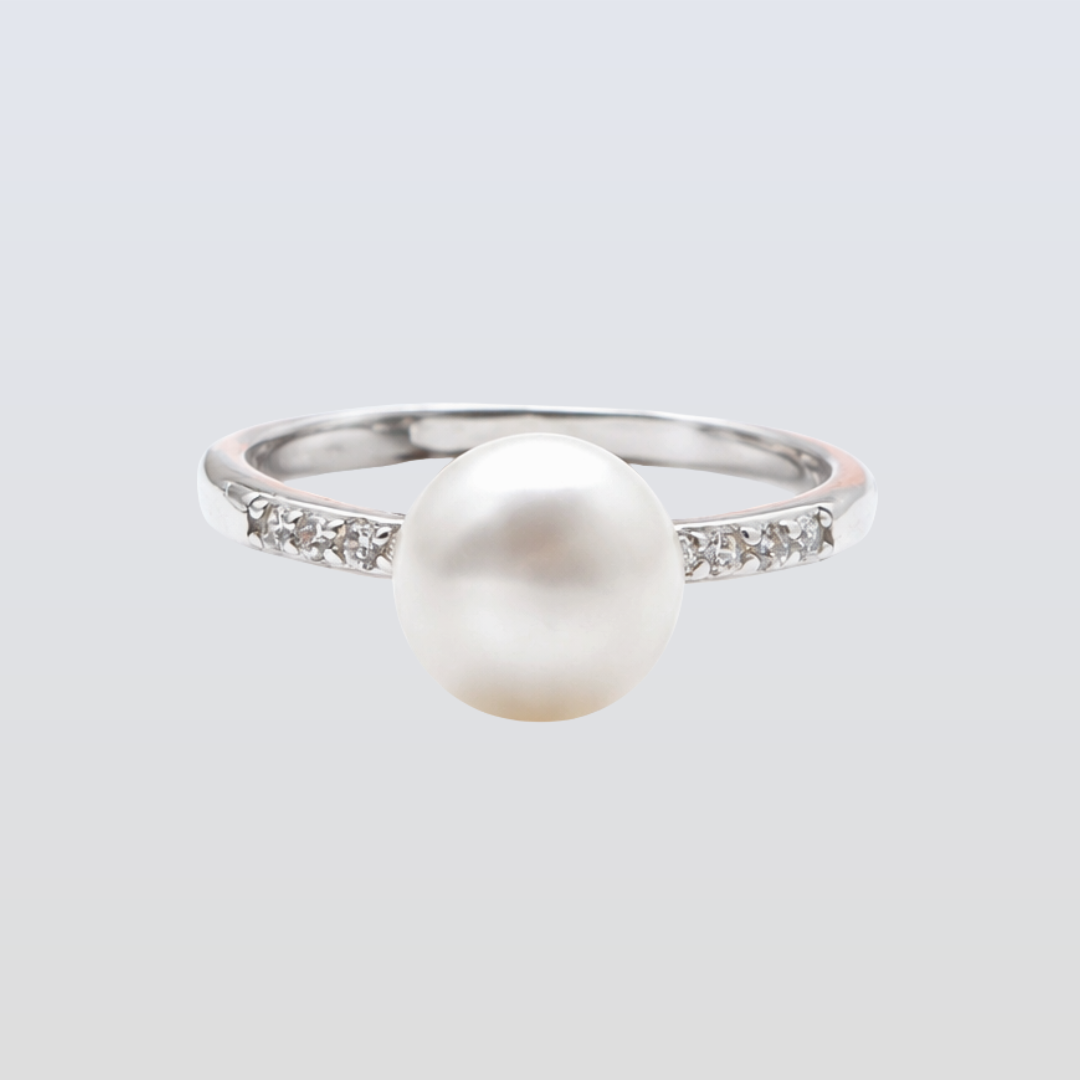 Pearl ring with a silver band on a light gray background