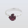 Silver ring with a large purple gemstone on a light gray background