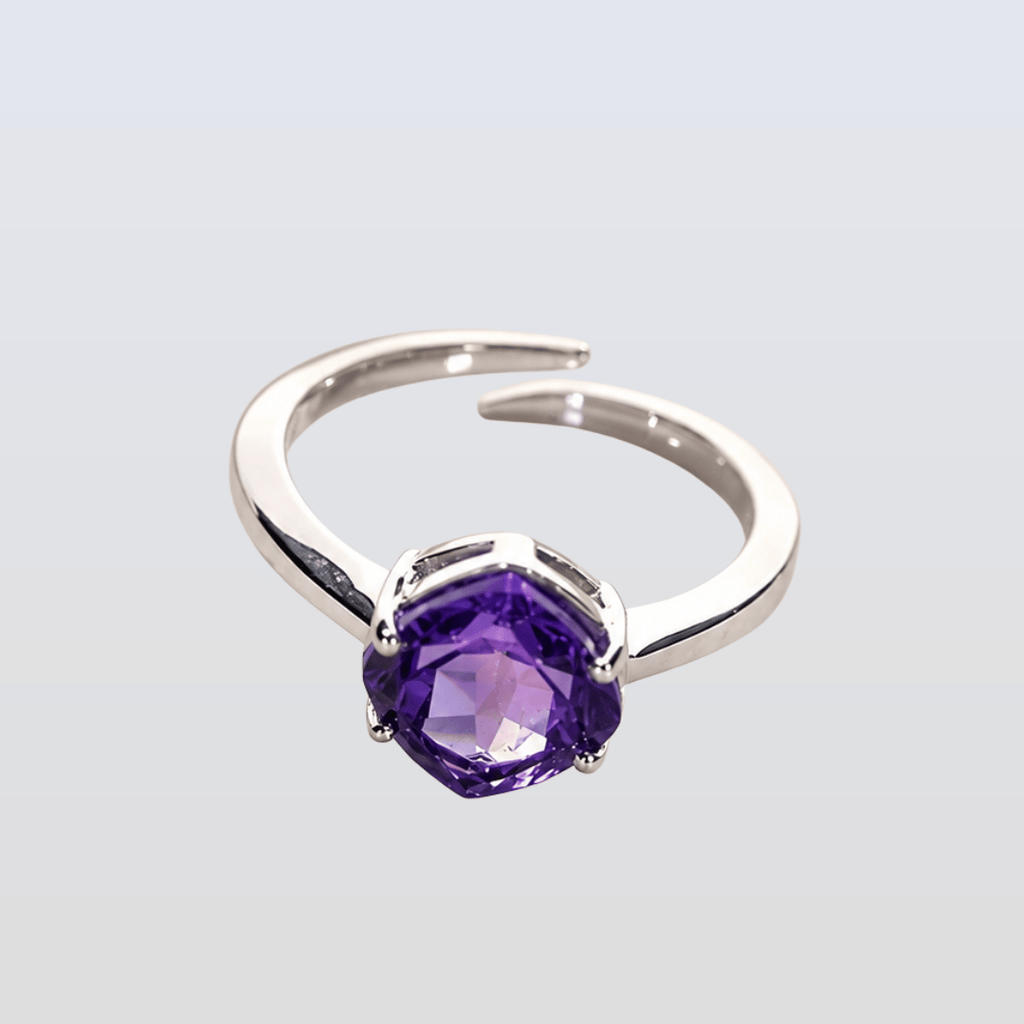 Silver ring with a purple gemstone on a light gray background