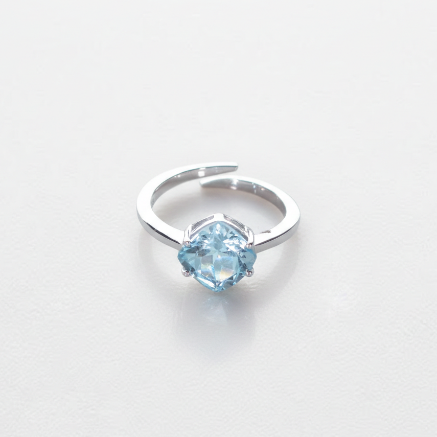 Silver ring with a blue gemstone on a light gray background

