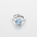 Silver ring with a blue gemstone on a light gray background

