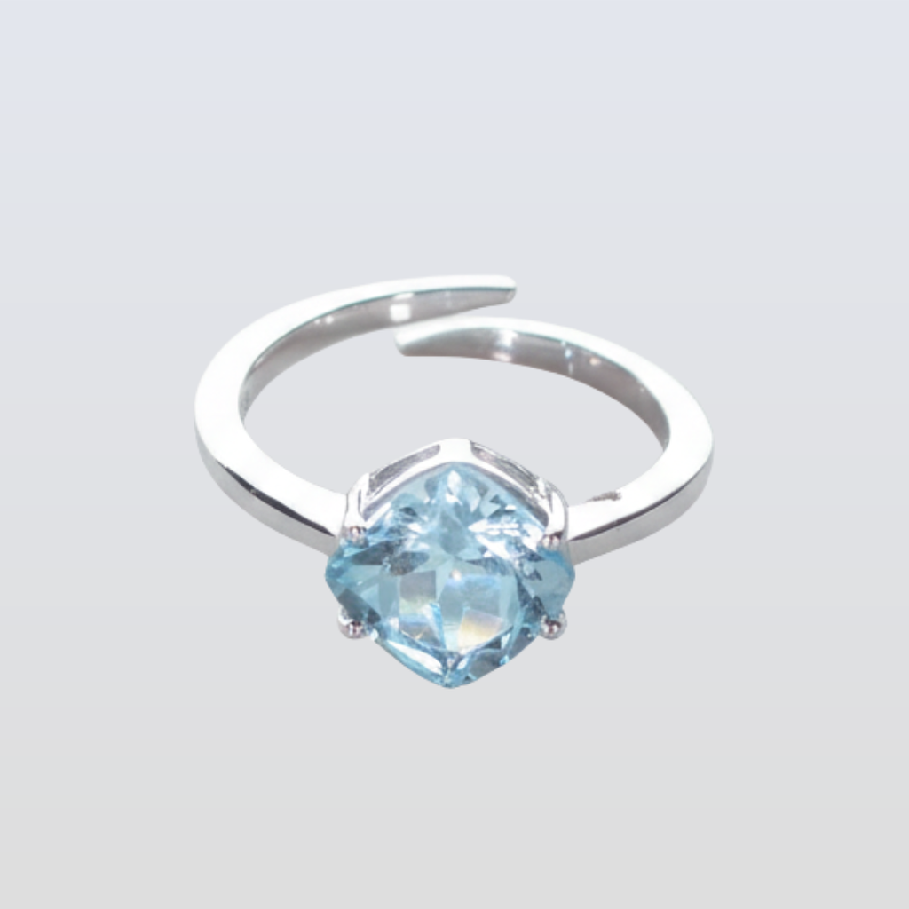 Silver ring with a blue gemstone on a light gray background