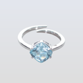 Silver ring with a blue gemstone on a light gray background