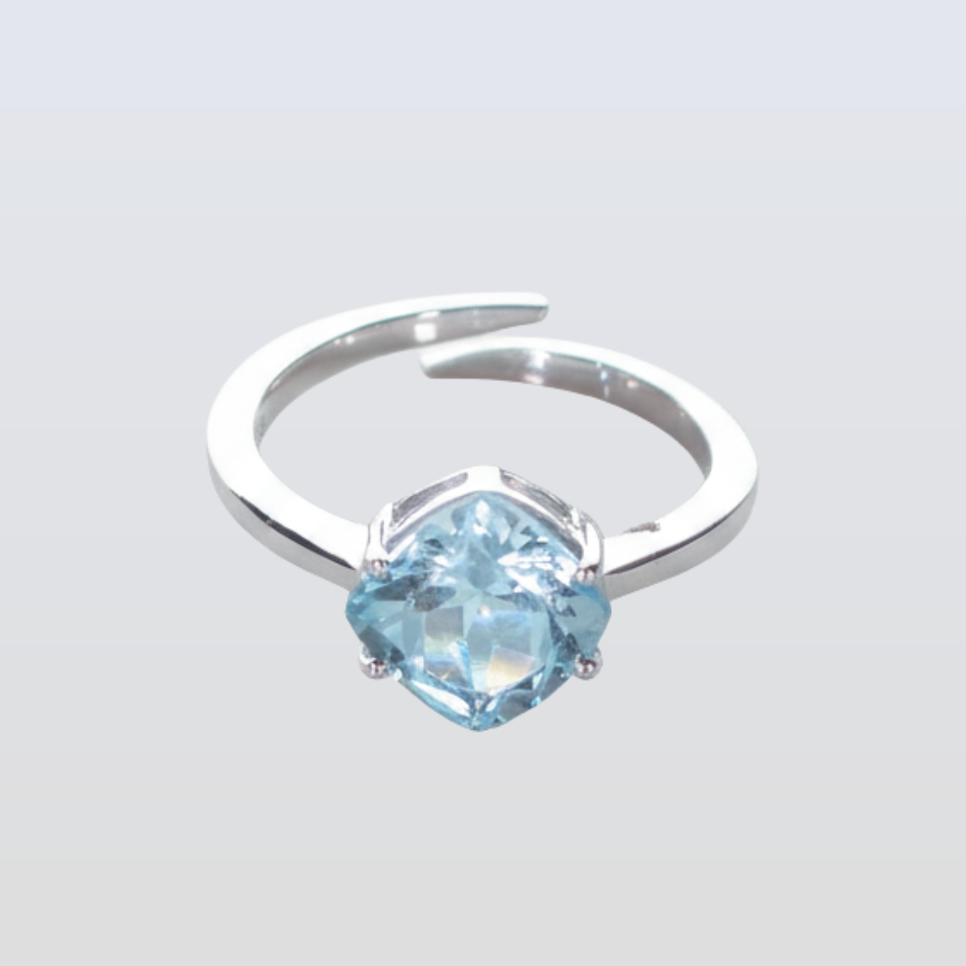 Silver ring with a blue gemstone on a light gray background