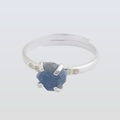 Silver ring with a blue stone on a light gray background