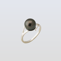 Silver ring with a black pearl on a light gray background