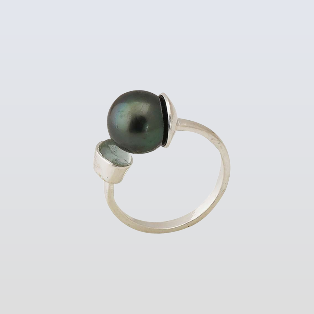 Silver ring with a black pearl on a light gray background