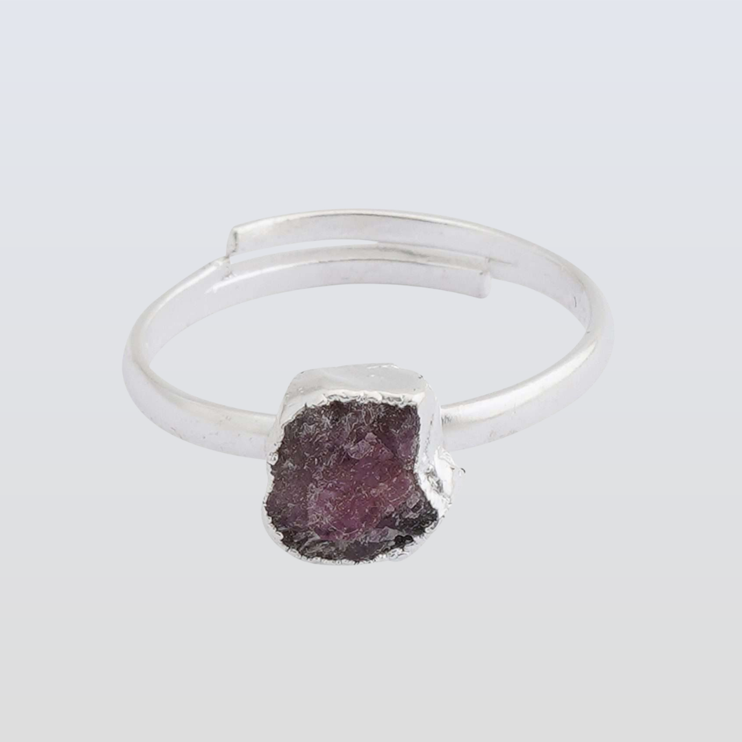Silver ring with a purple stone on a light gray background
