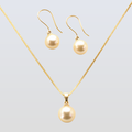 Gold necklace and earrings set on a light gray background