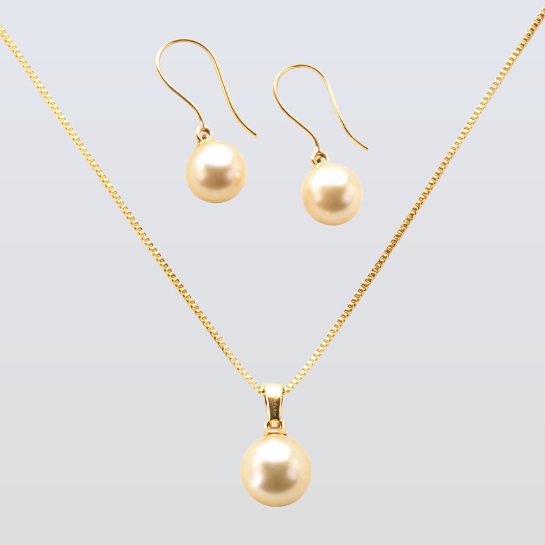 Gold necklace and earrings set on a light gray background