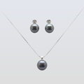 Pearl necklace and earrings set on a light gray background