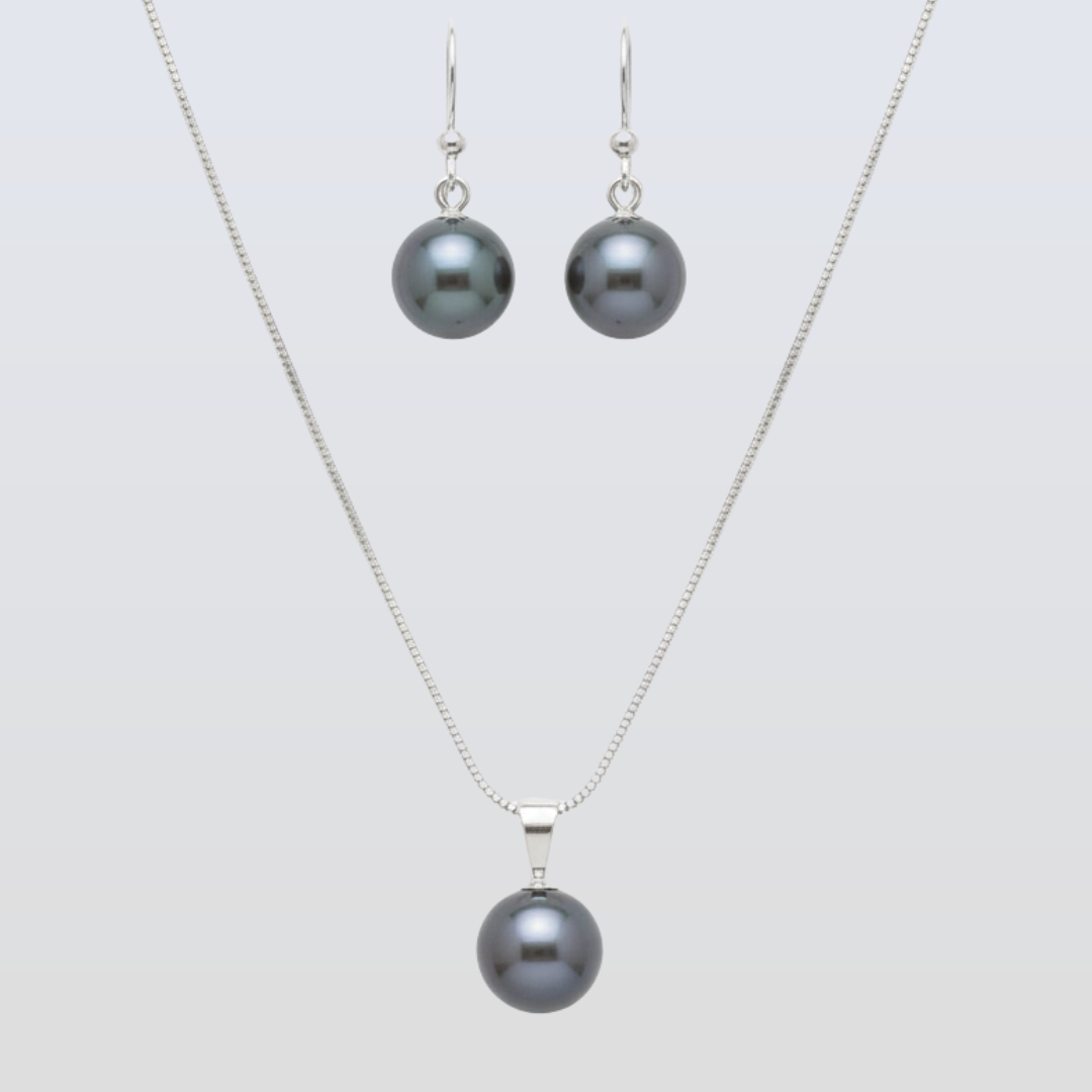 Pearl necklace and earrings set on a light gray background