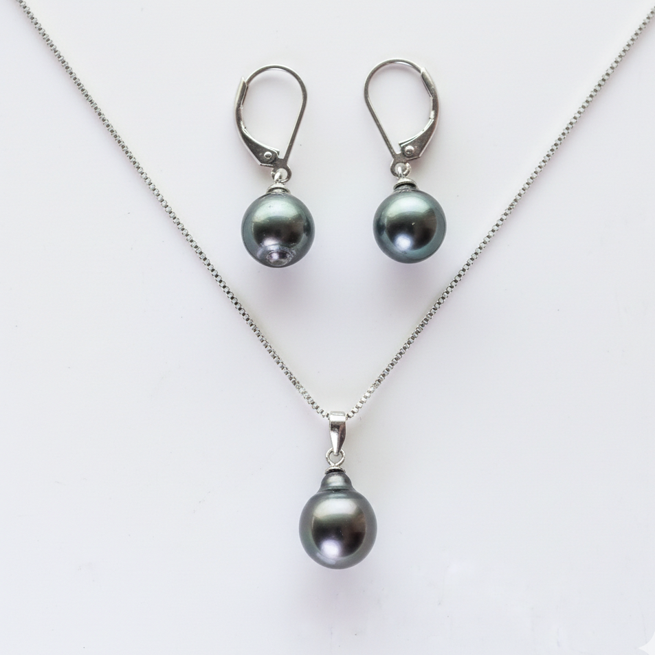 Pearl necklace and earrings set on a white background