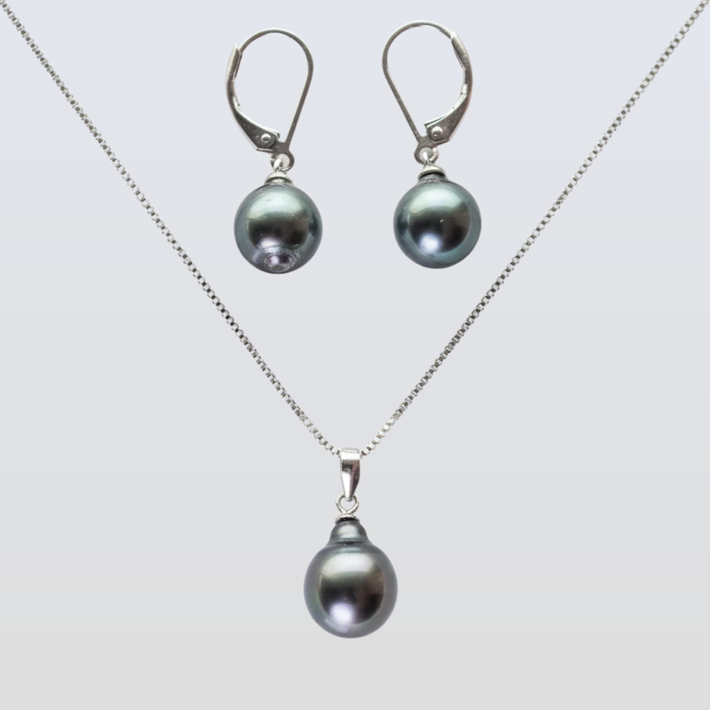 Pearl necklace and earrings set on a light gray background