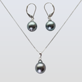 Pearl necklace and earrings set on a light gray background