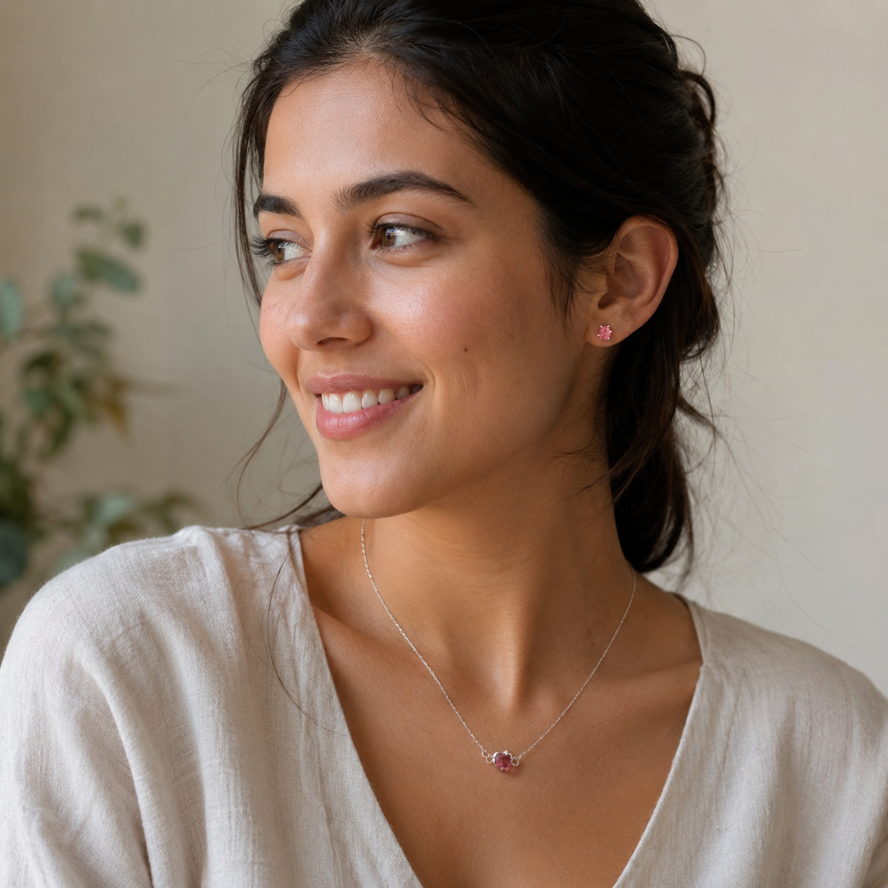 Woman wearing a necklace and earrings with a neutral background