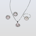 Pearl jewelry set with necklace, earrings, and ring on a light gray background