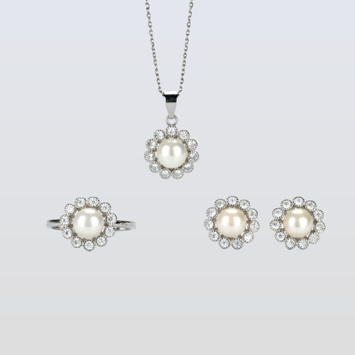 Pearl jewelry set with necklace, ring, and earrings on a light gray background