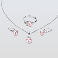 Pearl jewelry set with necklace, ring, and earrings on a light gray background