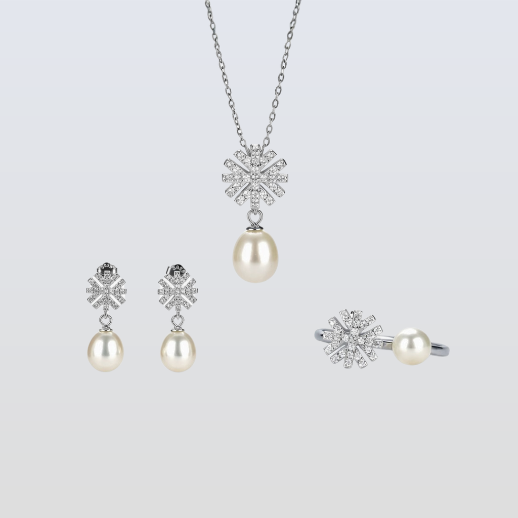 Pearl jewelry set with snowflake designs on a light gray background