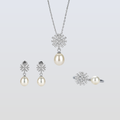 Pearl jewelry set with snowflake designs on a light gray background
