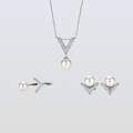 Pearl jewelry set with necklace, earrings, and ring on a light gray background