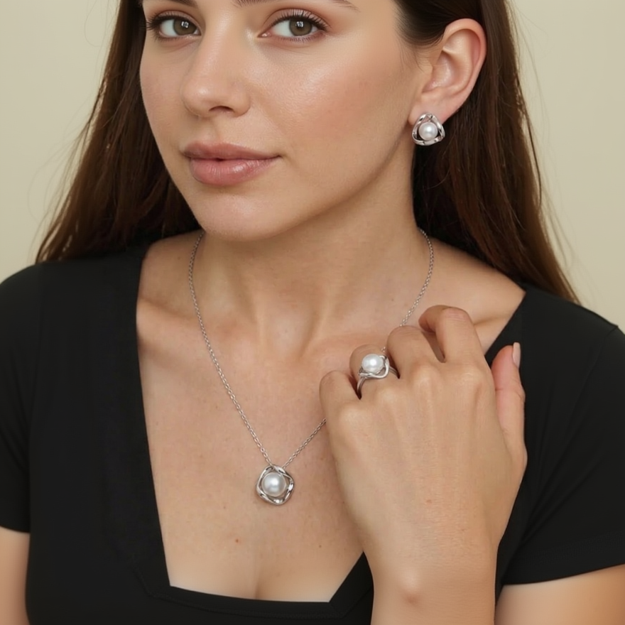 Pearl necklace and earrings on a model against a dark background